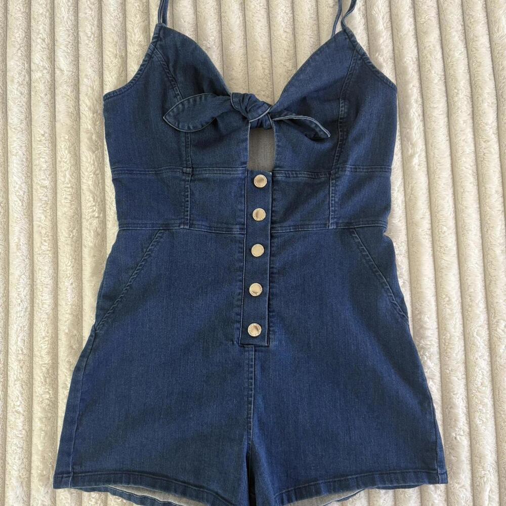 Denim romper in blue, with a button-up front and bow detail